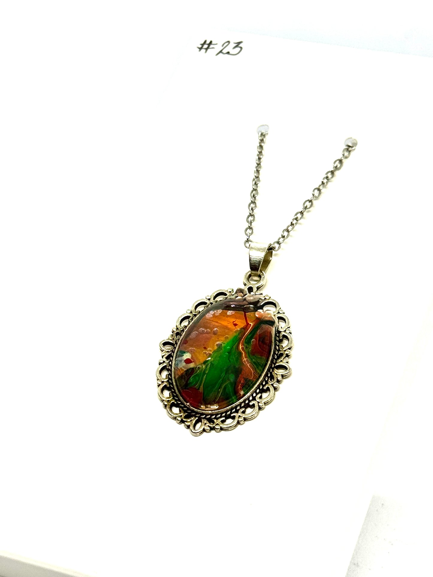 #23 “Don’t Look Too Long” Oval Pendant Necklace – Orange, Green & Red Paint Pour with Hidden Faces