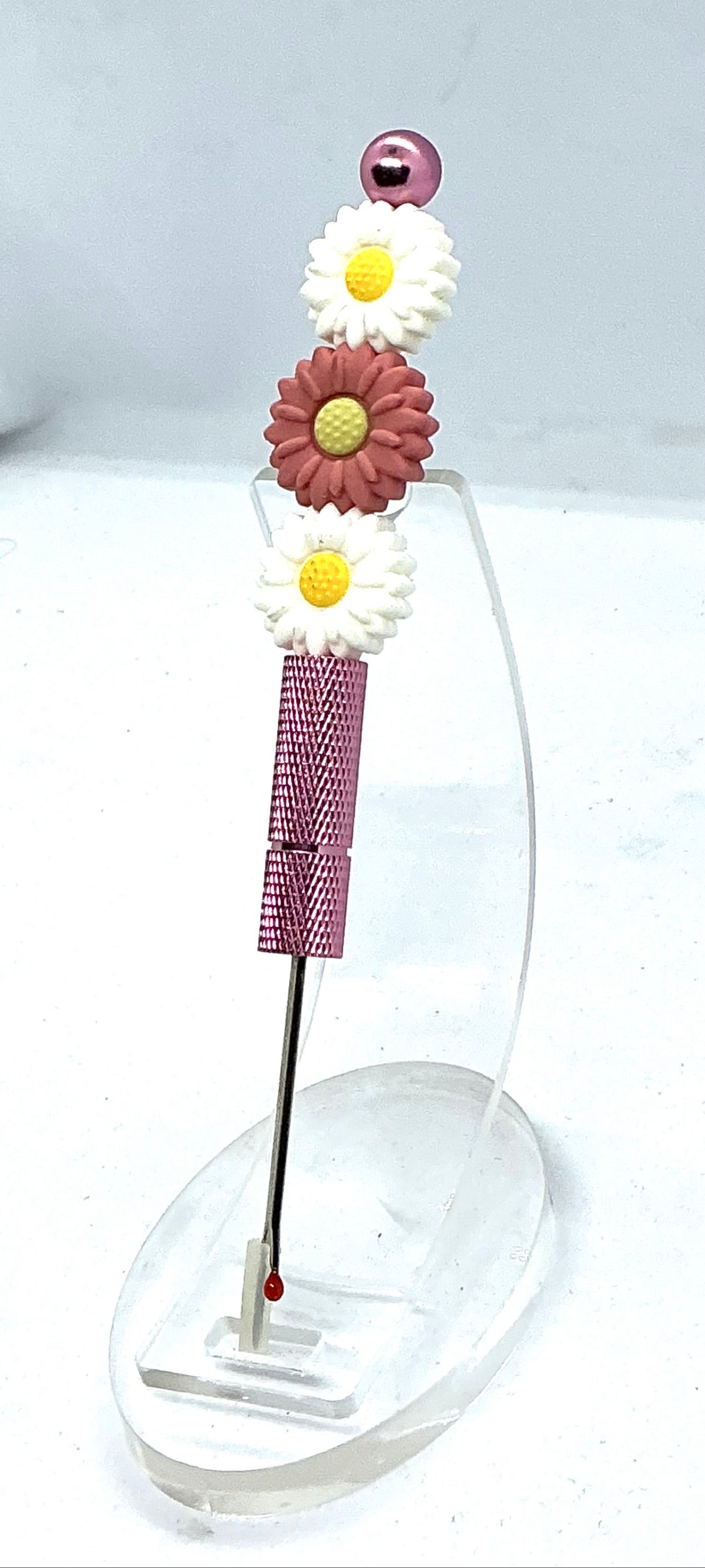 Beaded seam ripper with white and dusty rose daisy beads on a mauve-pink handle