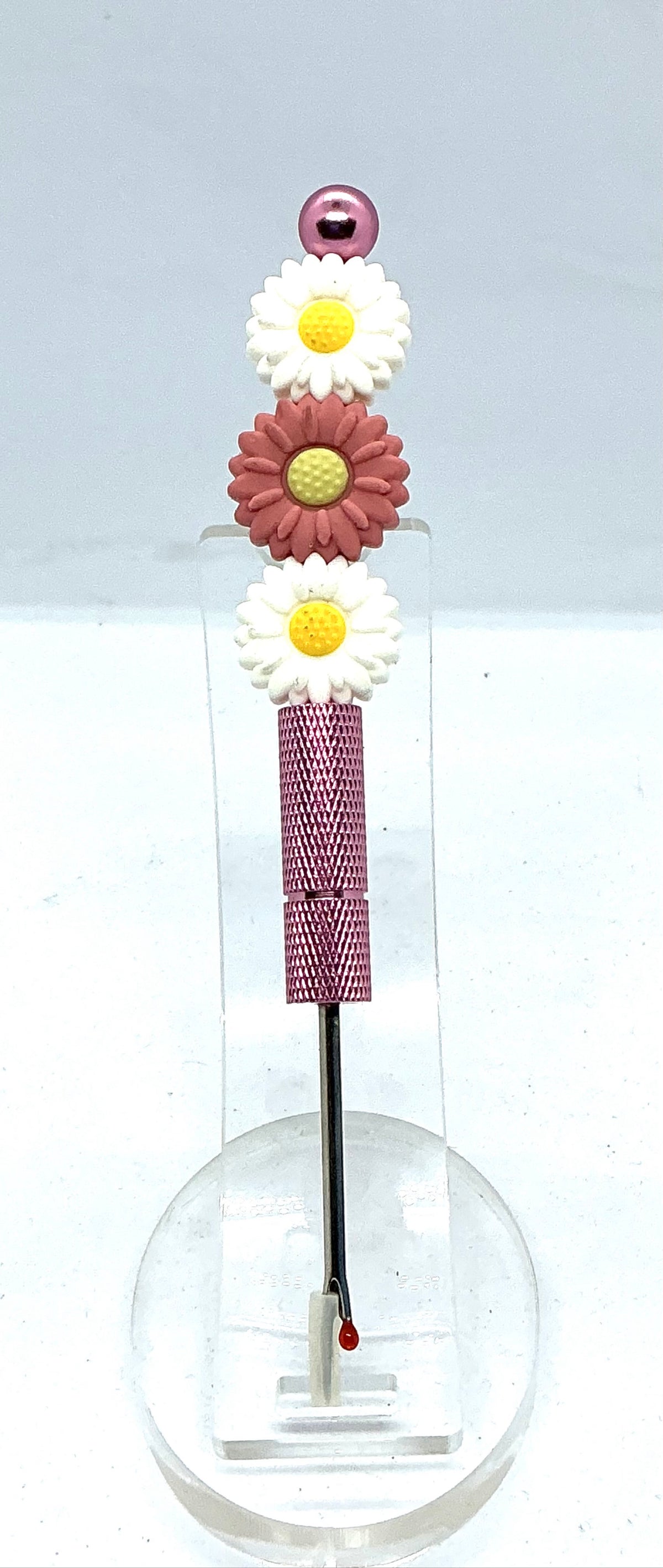 Beaded seam ripper with white and dusty rose daisy beads on a mauve-pink handle