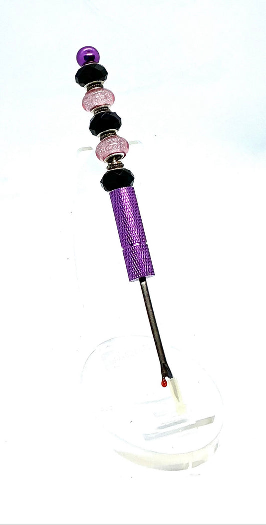 Beaded seam ripper with black faceted and pink glitter beads on a purple handle