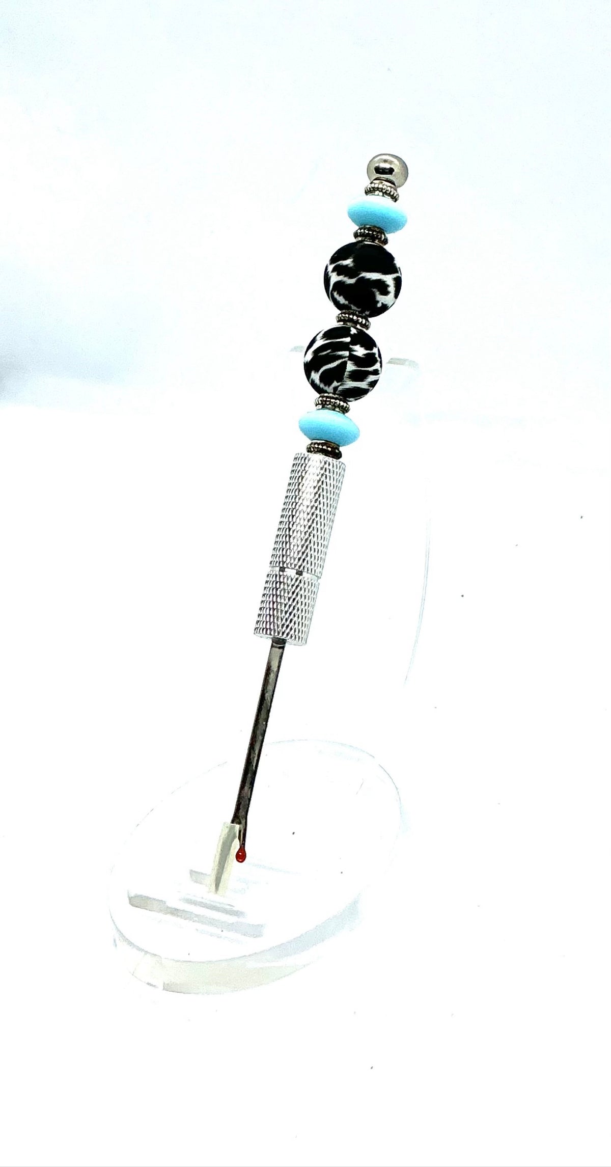 Beaded seam ripper with black-and-white zebra print beads and sky blue accents on a silver handle