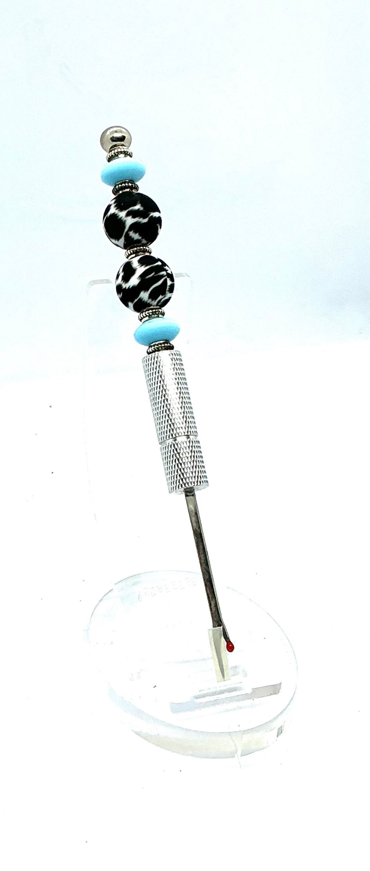 Beaded seam ripper with black-and-white zebra print beads and sky blue accents on a silver handle