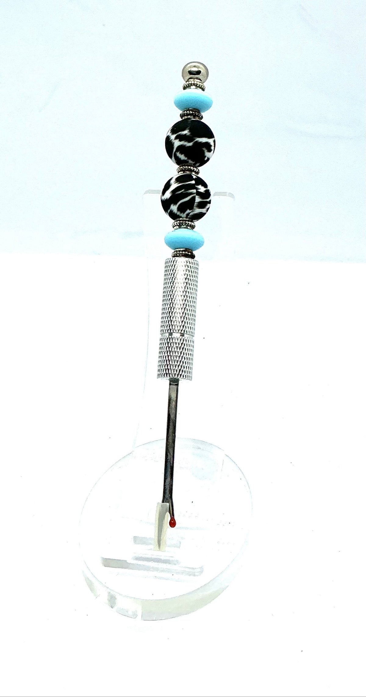 Beaded seam ripper with black-and-white zebra print beads and sky blue accents on a silver handle