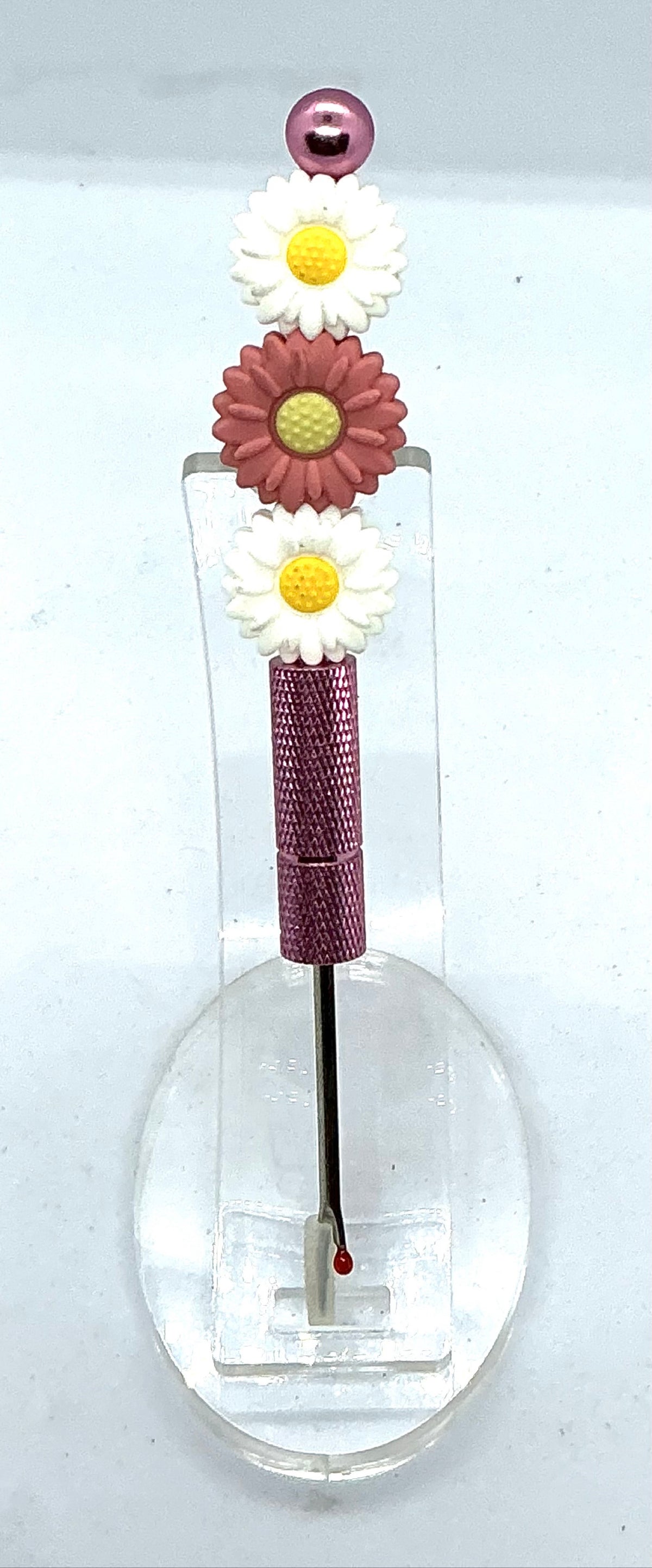 Beaded seam ripper with white and dusty rose daisy beads on a mauve-pink handle