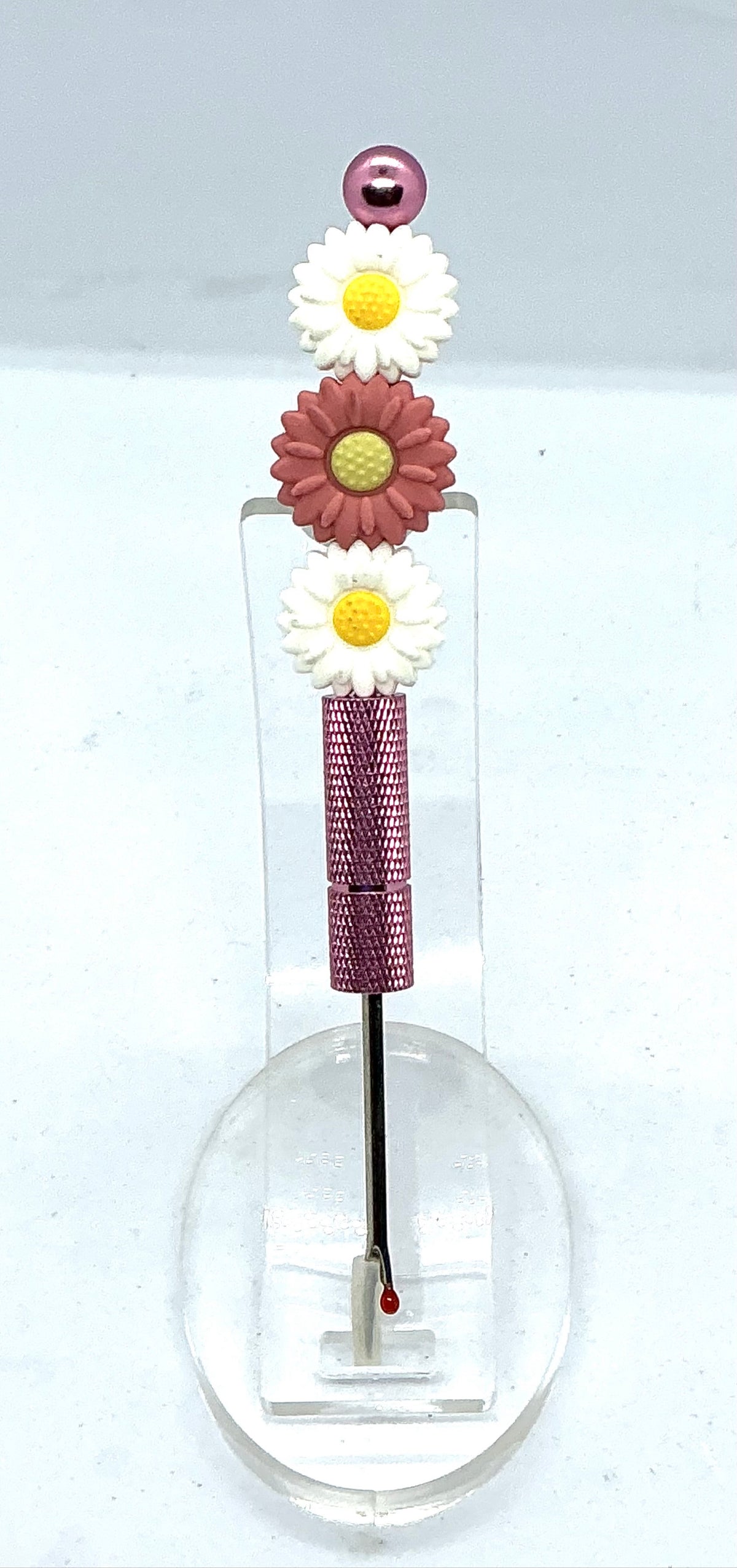 Beaded seam ripper with white and dusty rose daisy beads on a mauve-pink handle