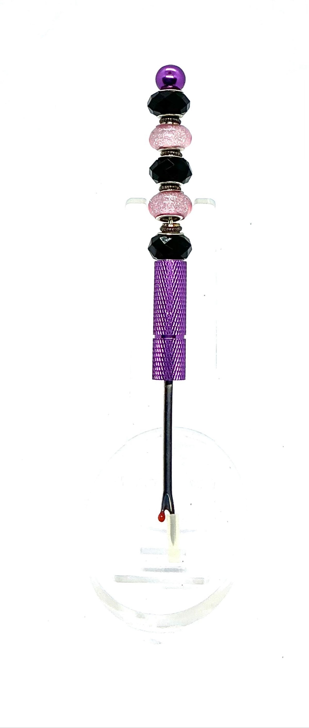 Beaded seam ripper with black faceted and pink glitter beads on a purple handle