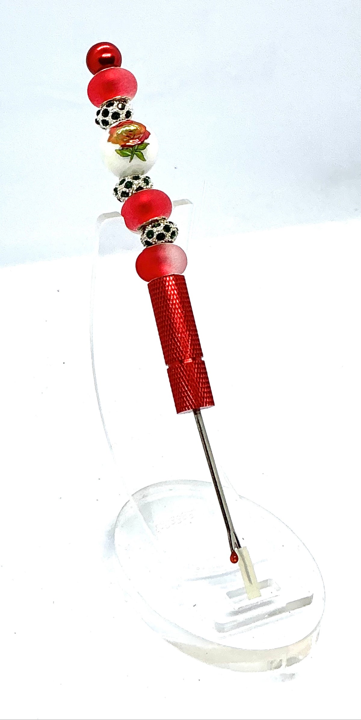 Beaded seam ripper with painted red rose bead and frosted red beads on a red handle