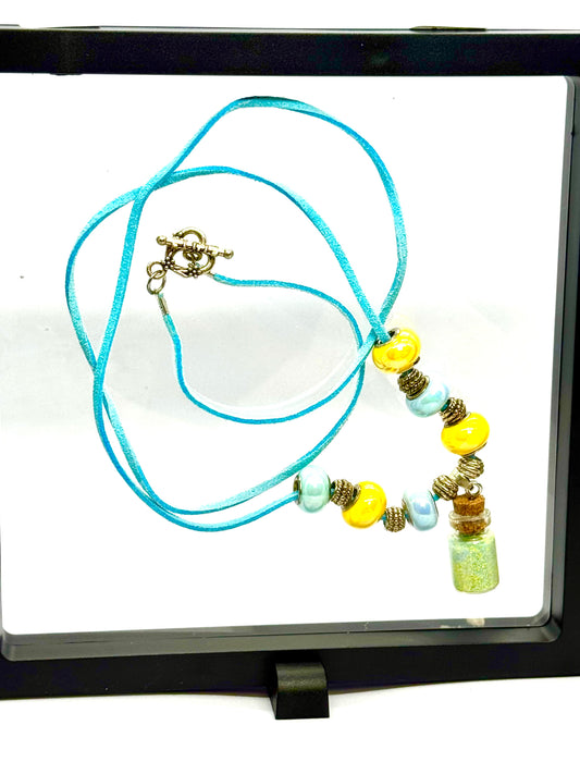“Calm on the Surface, Chaos in a Bottle” Blue Cord Beaded Necklace | 32” | Toggle Clasp | Glitter Bottle Pendant