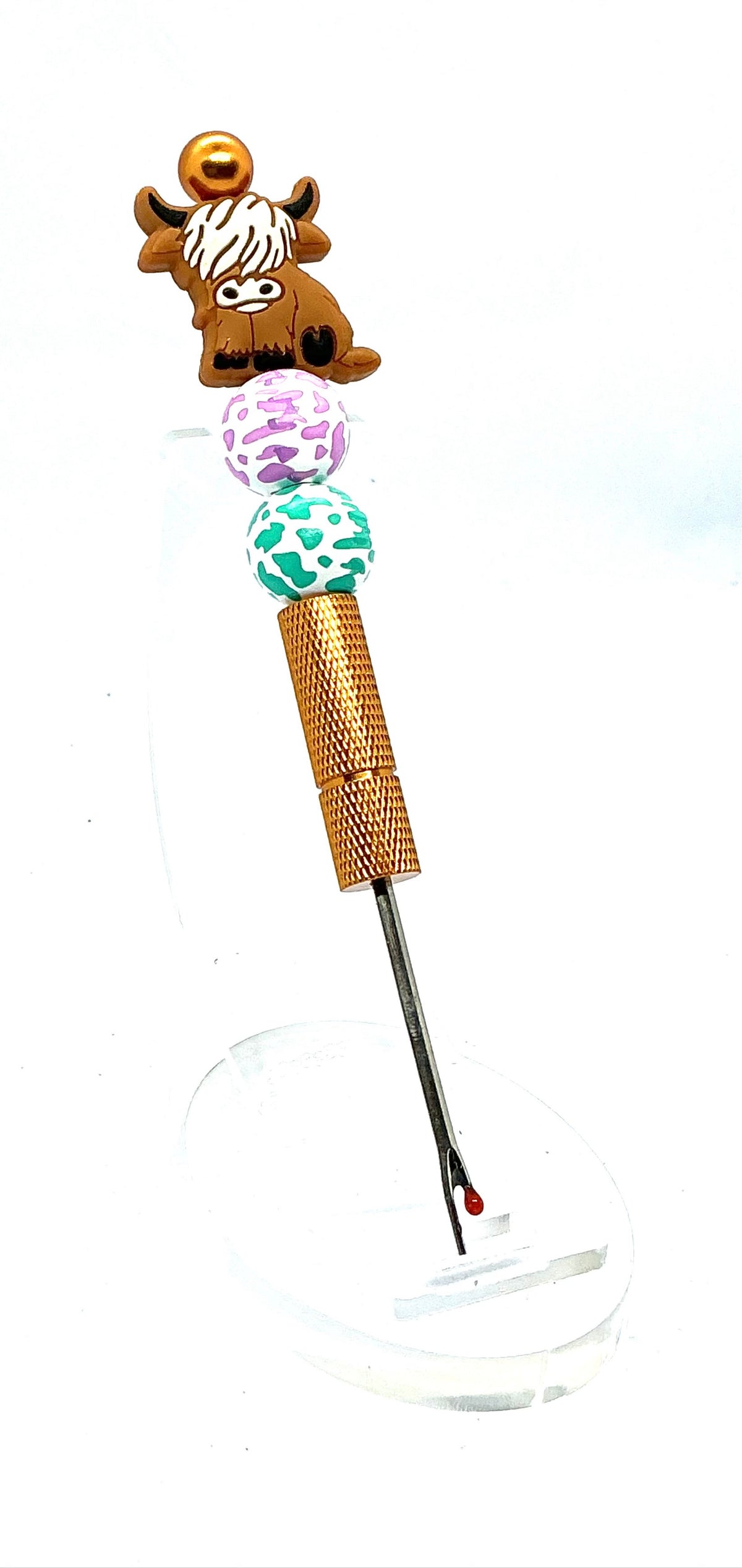 Beaded seam ripper with highland cow focal bead and purple and teal cow print beads on a gold handle
