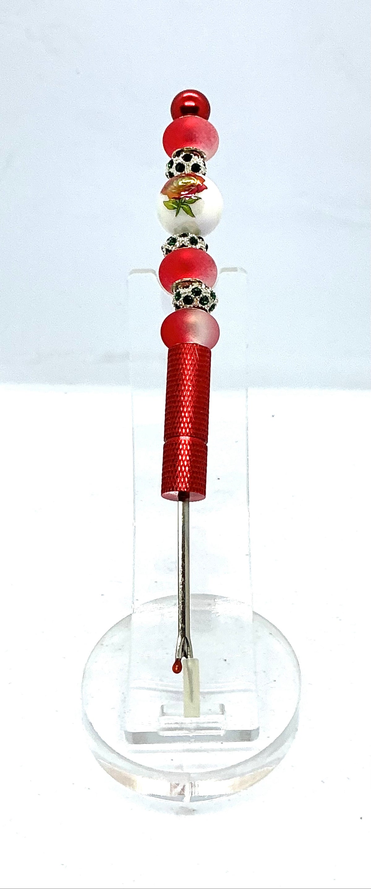 Beaded seam ripper with painted red rose bead and frosted red beads on a red handle