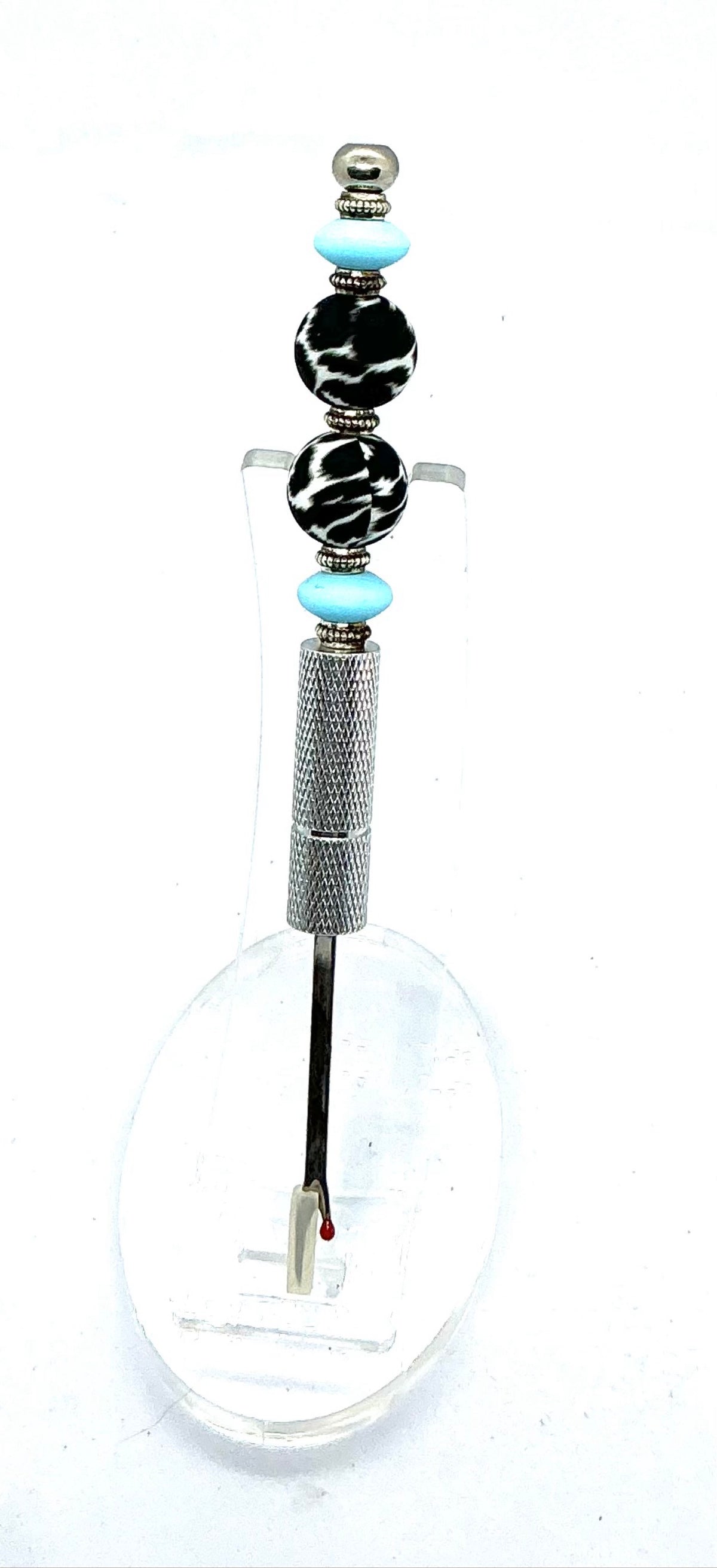 Beaded seam ripper with black-and-white zebra print beads and sky blue accents on a silver handle