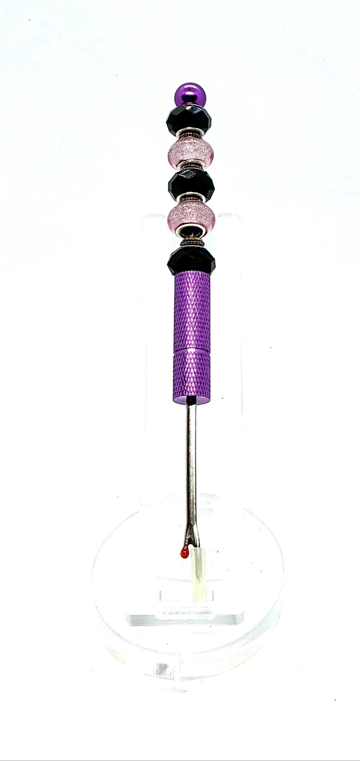 Beaded seam ripper with black faceted and pink glitter beads on a purple handle