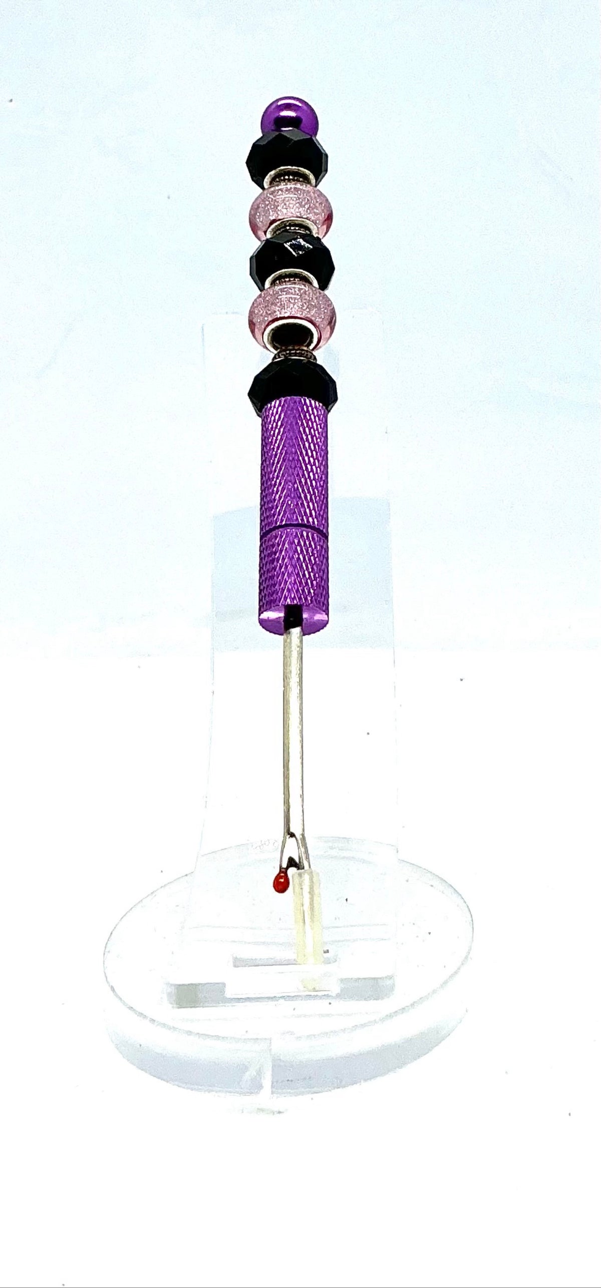 Beaded seam ripper with black faceted and pink glitter beads on a purple handle